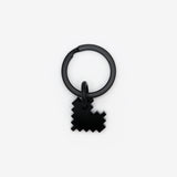 Pixelated black heart keyring on light grey background, glossy finish